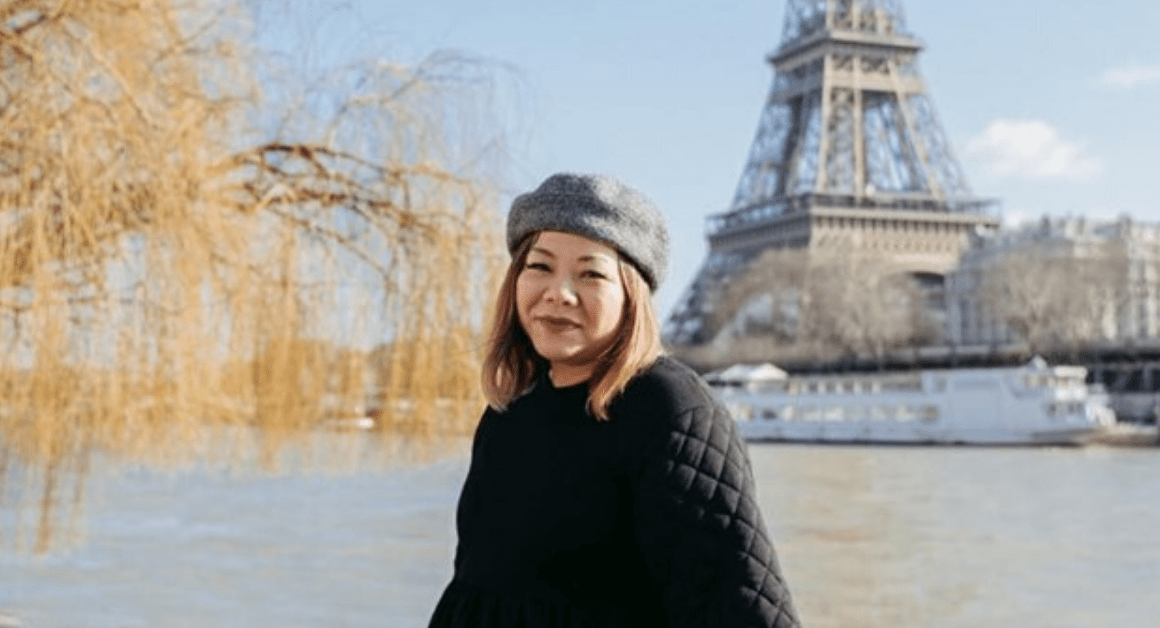 Christy Innouvong of Courageous Kitchen in Paris posing with the Eiffel Tower