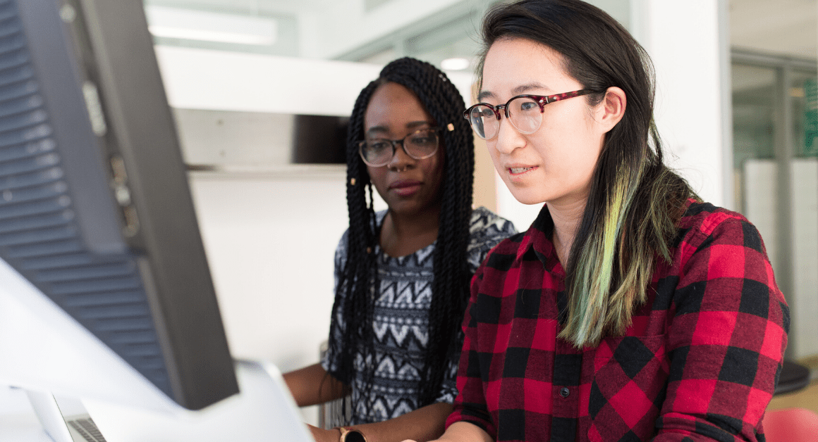 Asian American and African American women working together at a computer